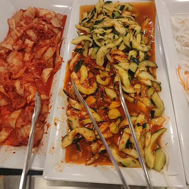 Dining room tables beside a salad bar.